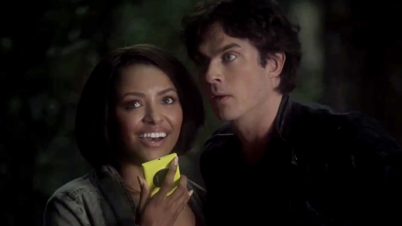 Bonnie and Damon from &#x27;The Vampire Diaries&#x27; show, Bonnie holding a phone, both standing outdoors at night