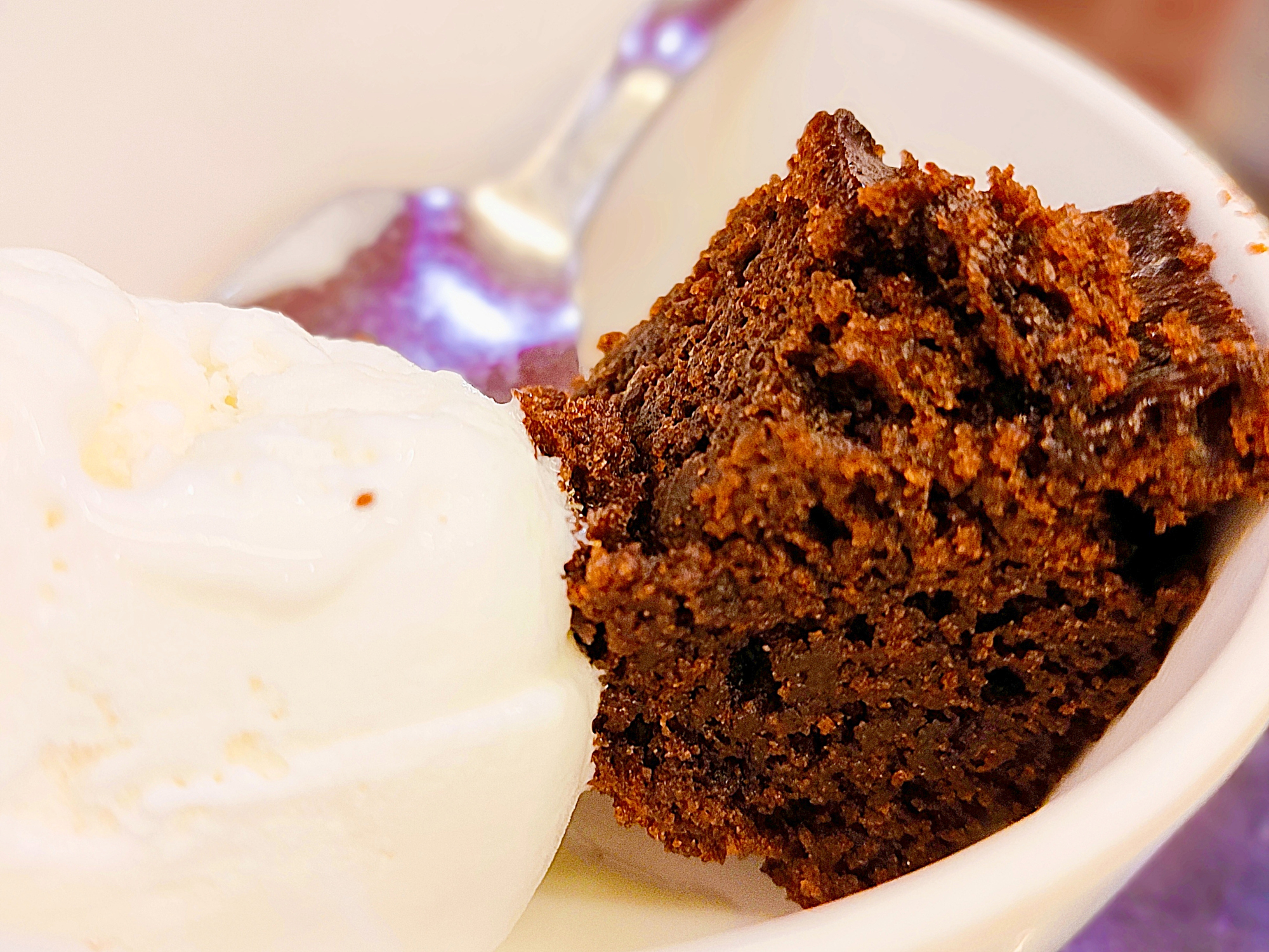 A close-up of chocolate cake with a scoop of vanilla ice cream on the side