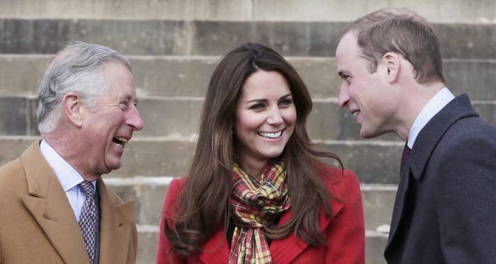 Charles, William, and Kate Middleton smiling and engaged in a conversation outdoors