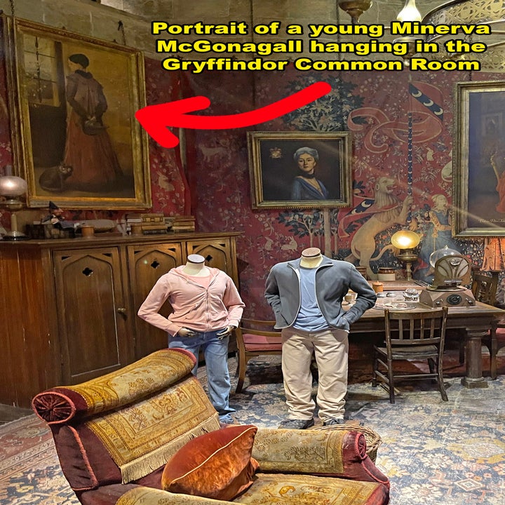 Two people viewing a young Minerva McGonagall portrait in a Gryffindor-themed room