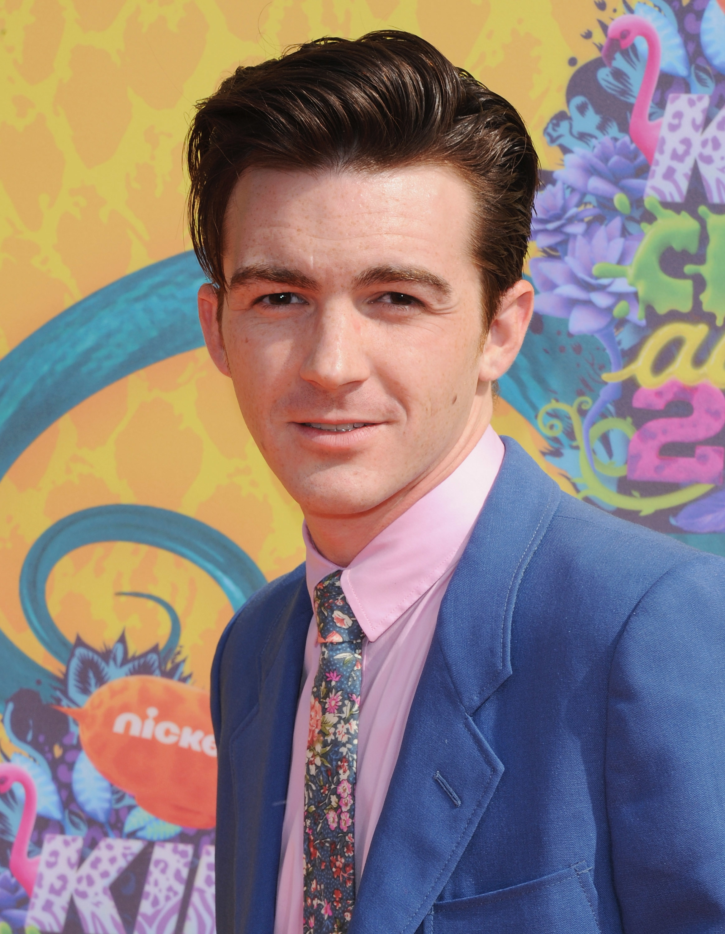 Drake Bell in a blue suit with a floral shirt at the Nickelodeon event