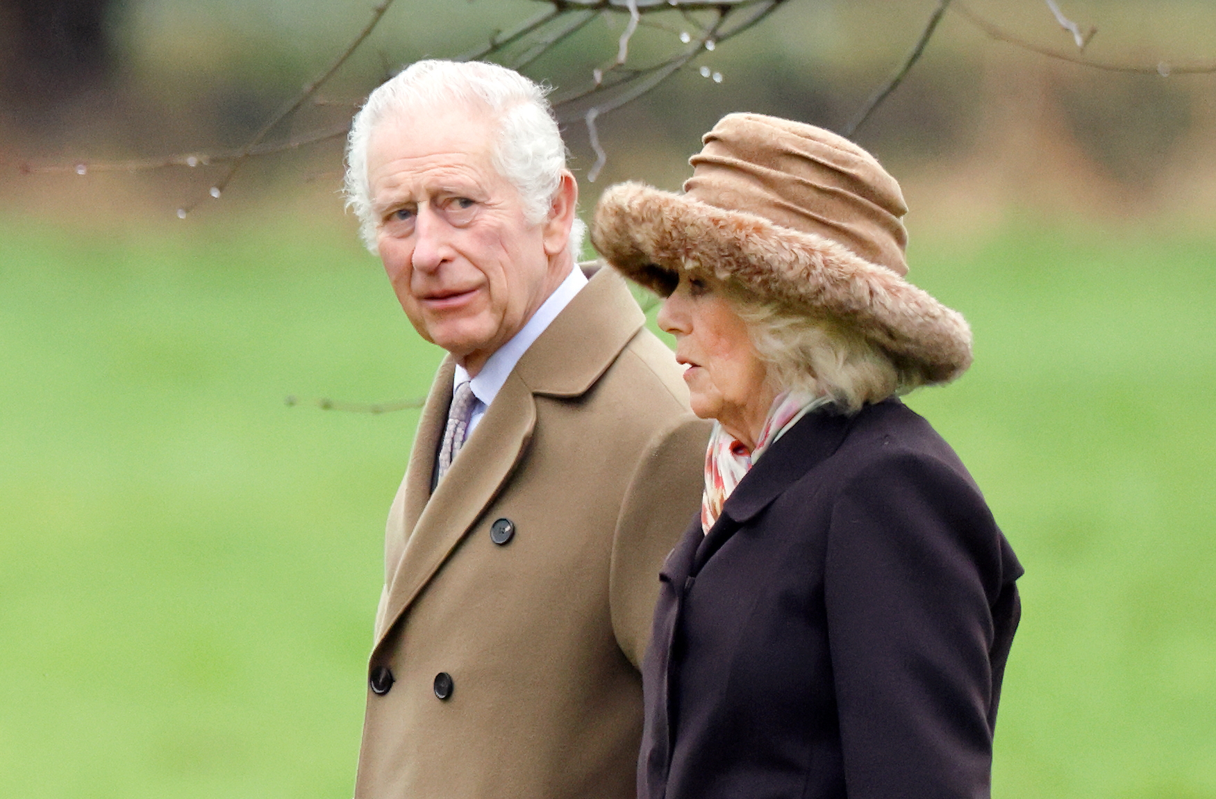 Closeup of King Charles and Queen Camilla walking outside wearing winter coats