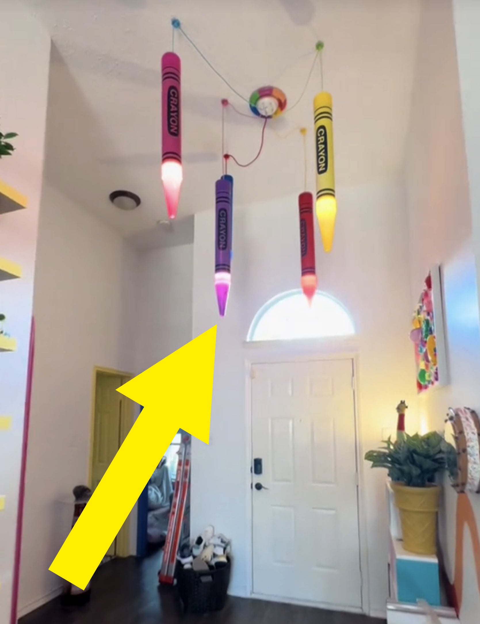 Room with crayon-shaped lights, assorted decor, and a skateboard near the entrance