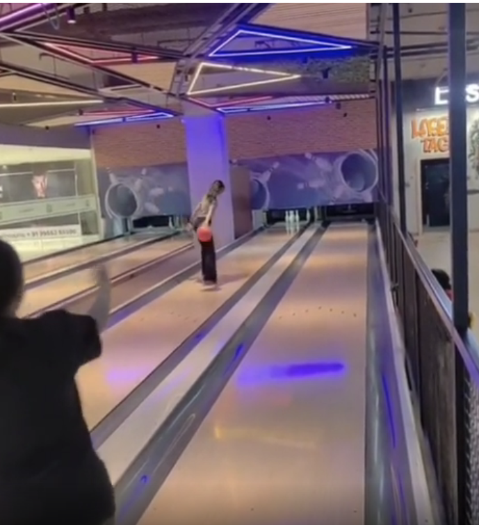 a person bowling, but standing way down the lane where they&#x27;re not supposed to