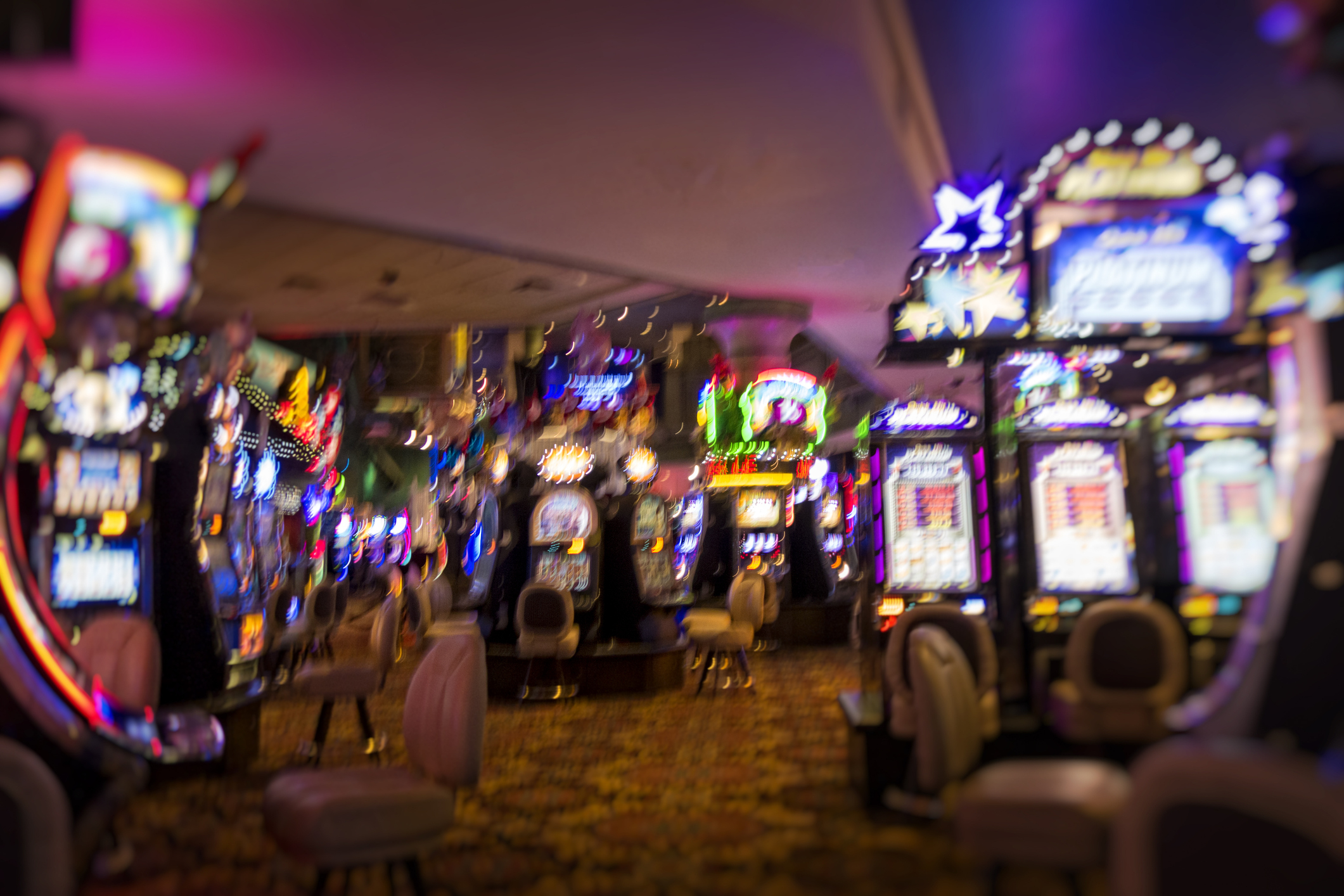 Blurred casino interior with slot machines and no identifiable people