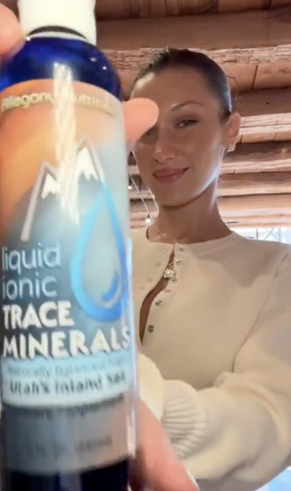 Bella holding a bottle of liquid ionic trace minerals, smiling at the camera