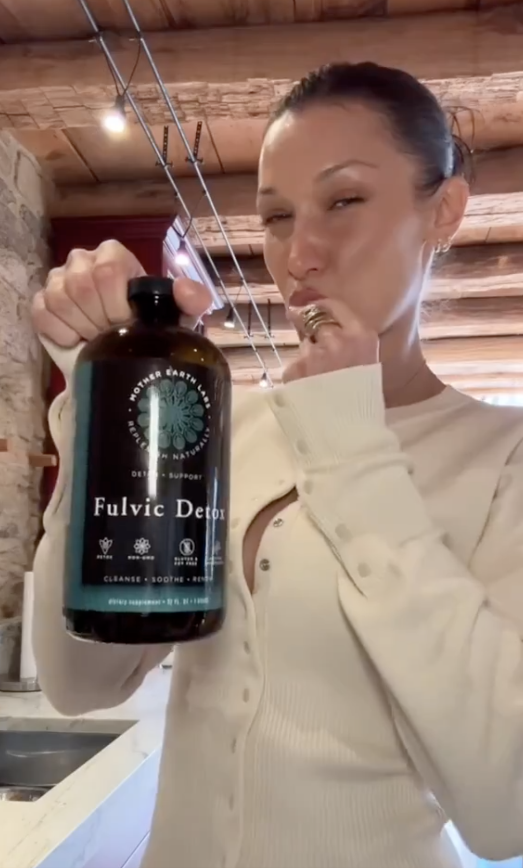 Bella holding a bottle of Fulvic Detox, with her lips pursed