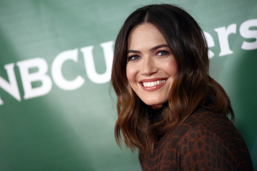Mandy with shoulder-length hair smiling at an NBCUniversal event, wearing a patterned outfit