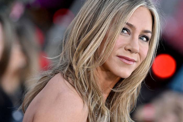 Close-up of Jennifer Aniston with a soft smile, wearing a stylish outfit