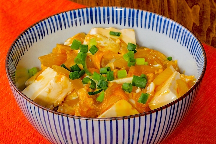 しょうがとねぎをトッピングした豆腐とキャベツのあんかけが入ったどんぶり。