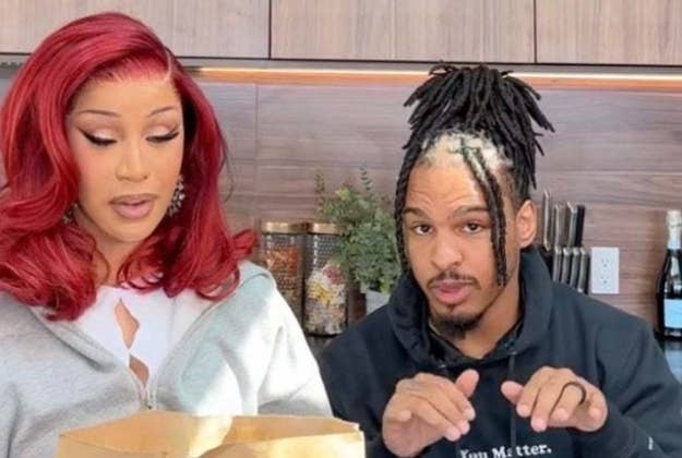 Cardi B and Chance the Rapper stand together looking at a table, possibly evaluating food or products