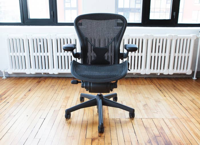 Ergonomic office chair in a room with wooden flooring and large windows