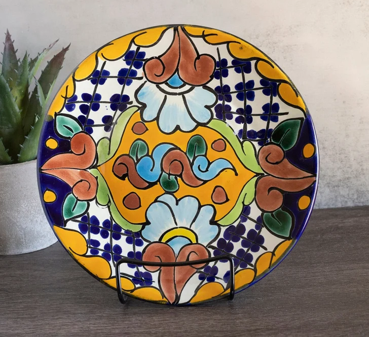 Decorative ceramic plate with a colorful floral pattern displayed on a stand