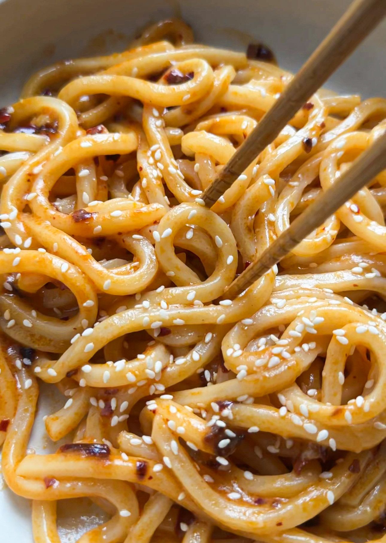 Bowl of noodles with sesame seeds and chopsticks