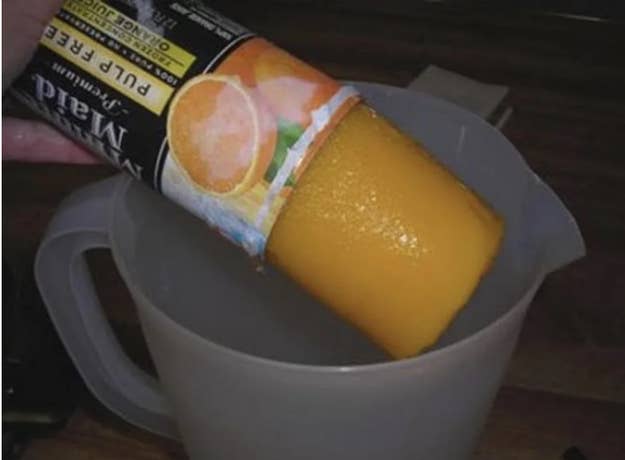 Frozen juice concentrate being emptied from carton into a mug