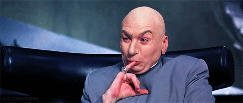 Dr Evil from Austin Powers films gestures with hand, seated, in a plotting pose