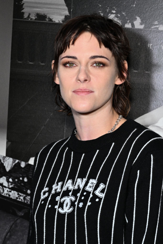 Kristen with short hair wearing a striped Chanel top, posing for the camera