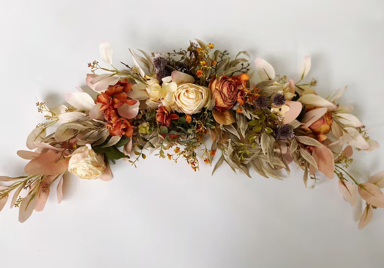Floral arrangement with various flowers and leaves on a plain background