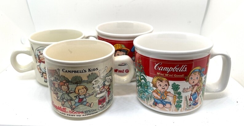 Collection of four vintage Campbell&#x27;s soup mugs with various illustrations of the Campbell Kids characters