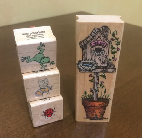 Four wooden blocks with animal and plant stamps against a table