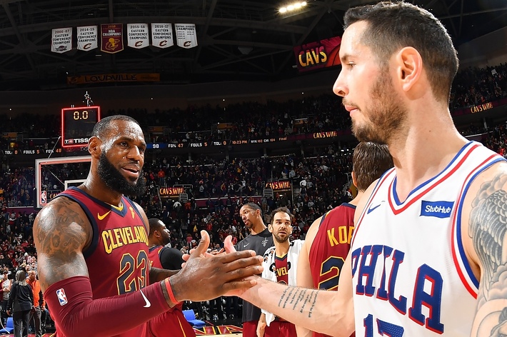 LeBron James in a Cavaliers jersey shakes hands with a 76ers player post-game on the basketball court