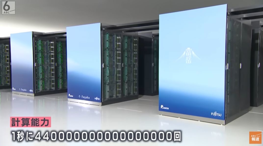 スーパーコンピューターの並ぶ部屋、画面には富士山の画像と富士通のロゴ
