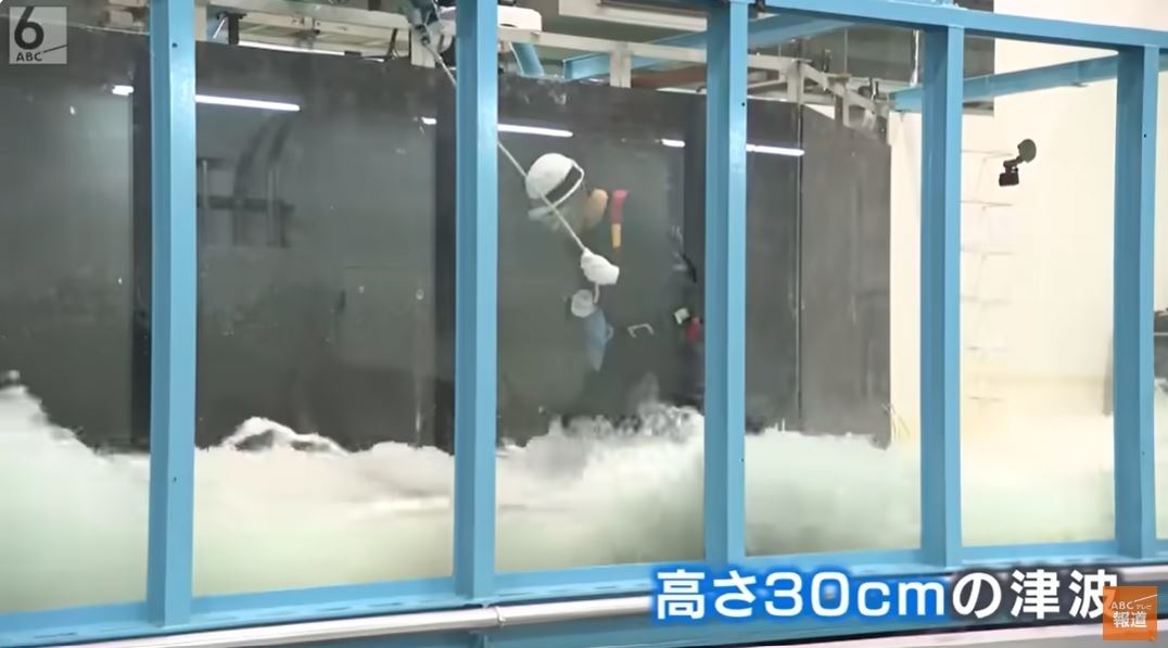 実験装置内で激しい波を扱う研究者。