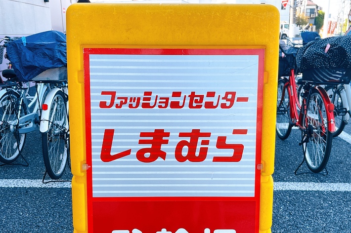 Sign with Japanese text in front of bicycles, possibly conveying a message or instruction