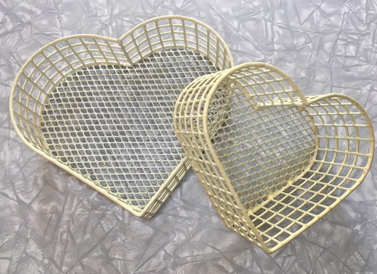 Two heart-shaped wicker baskets on a textured surface