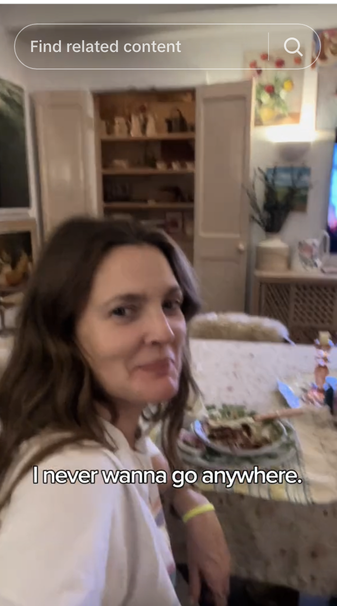 Drew Barrymore in a dining room smiling at the camera
