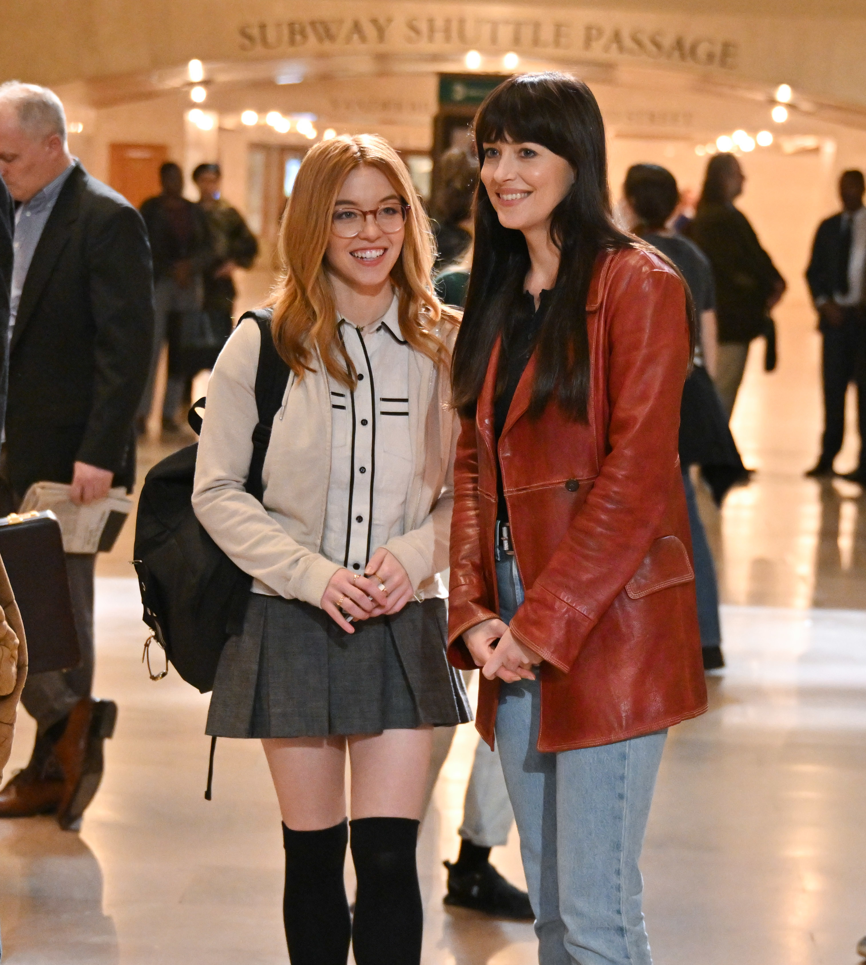 Sydney Sweeney and Dakota Johnson stand in a grand subway terminal in a scene from Madame Webb