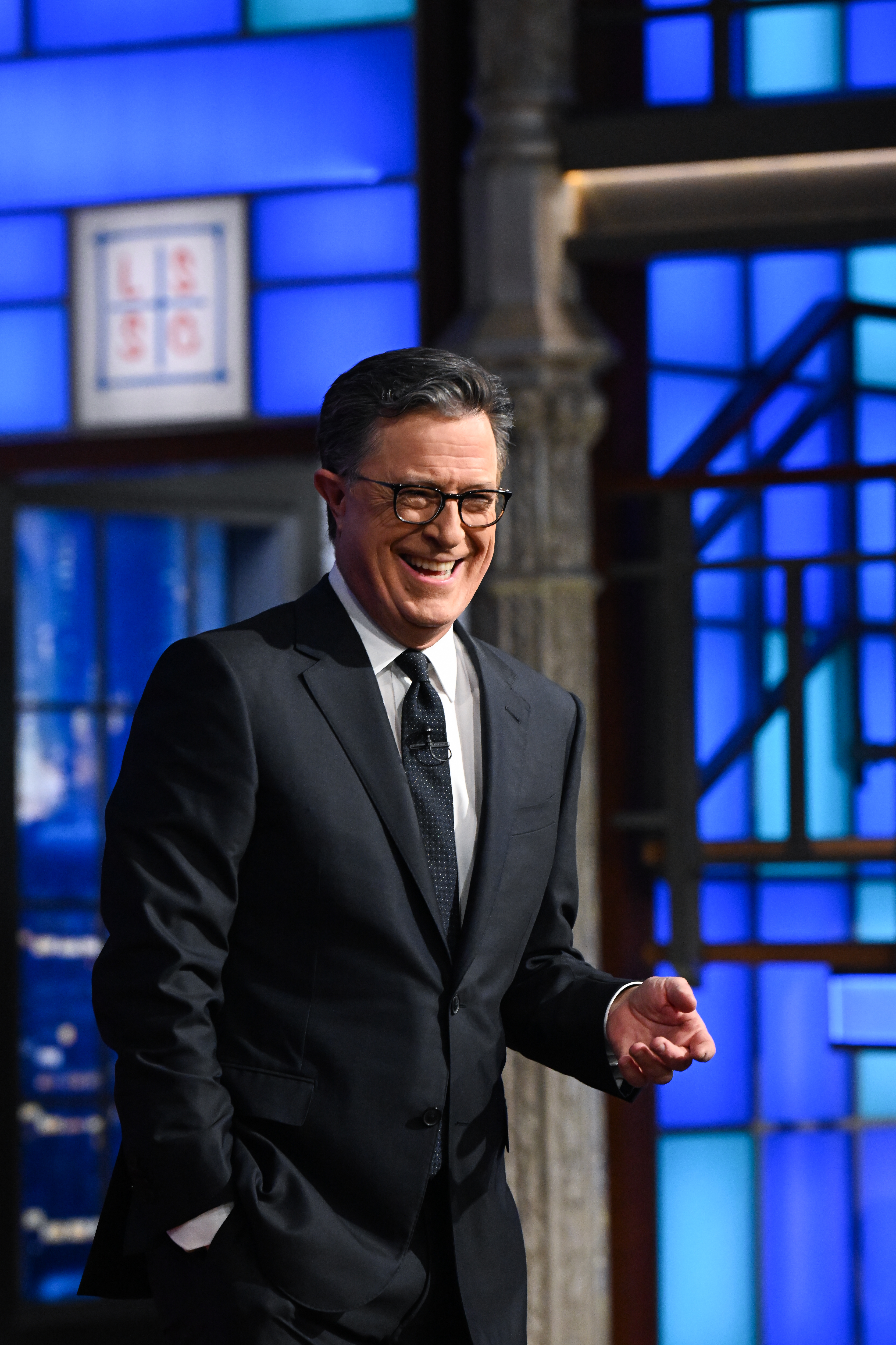 Stephen Colbert in a classic suit, hosting his late-night talk show