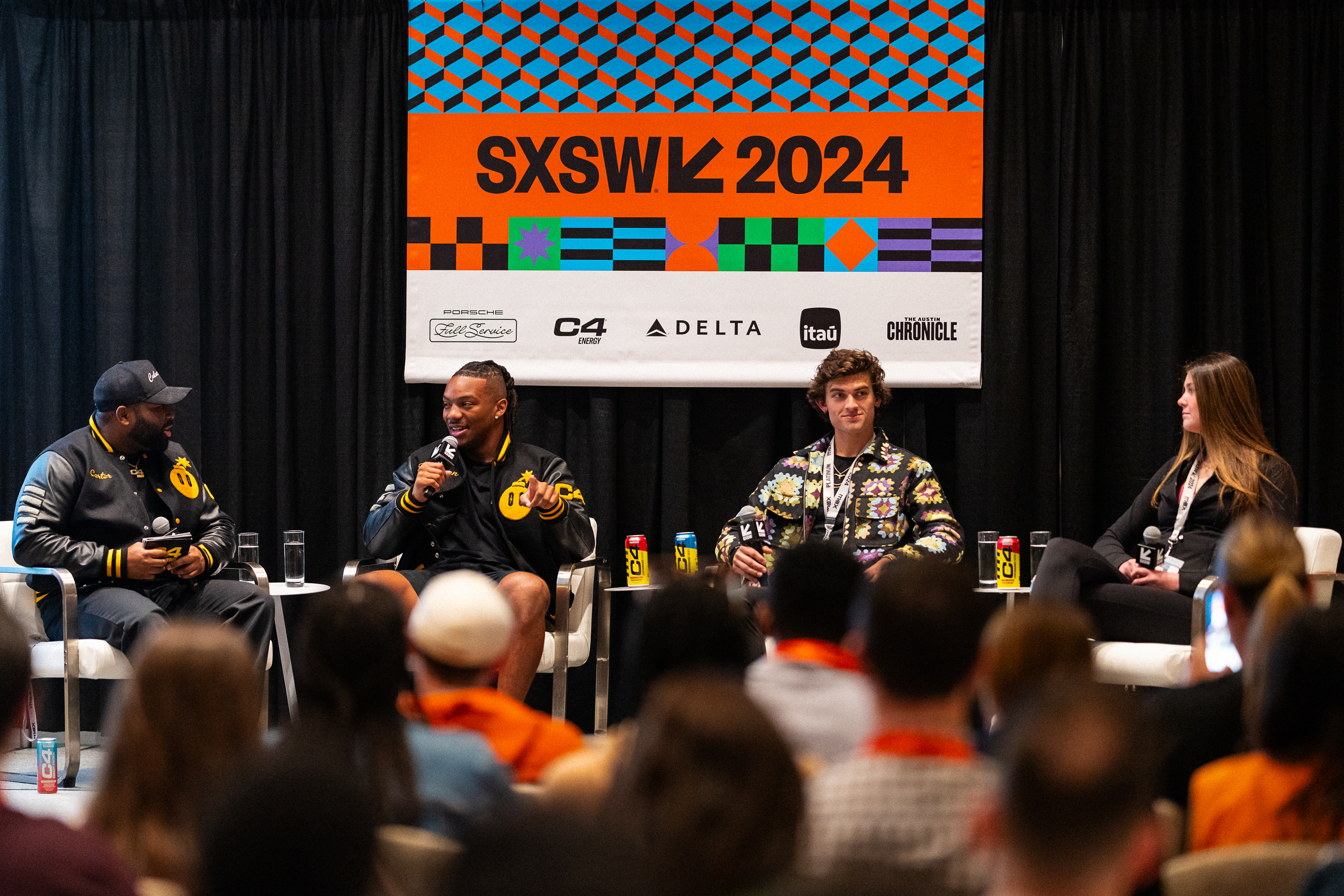 Four panelists at SXSW 2024, seated, engaged in a discussion in front of an audience