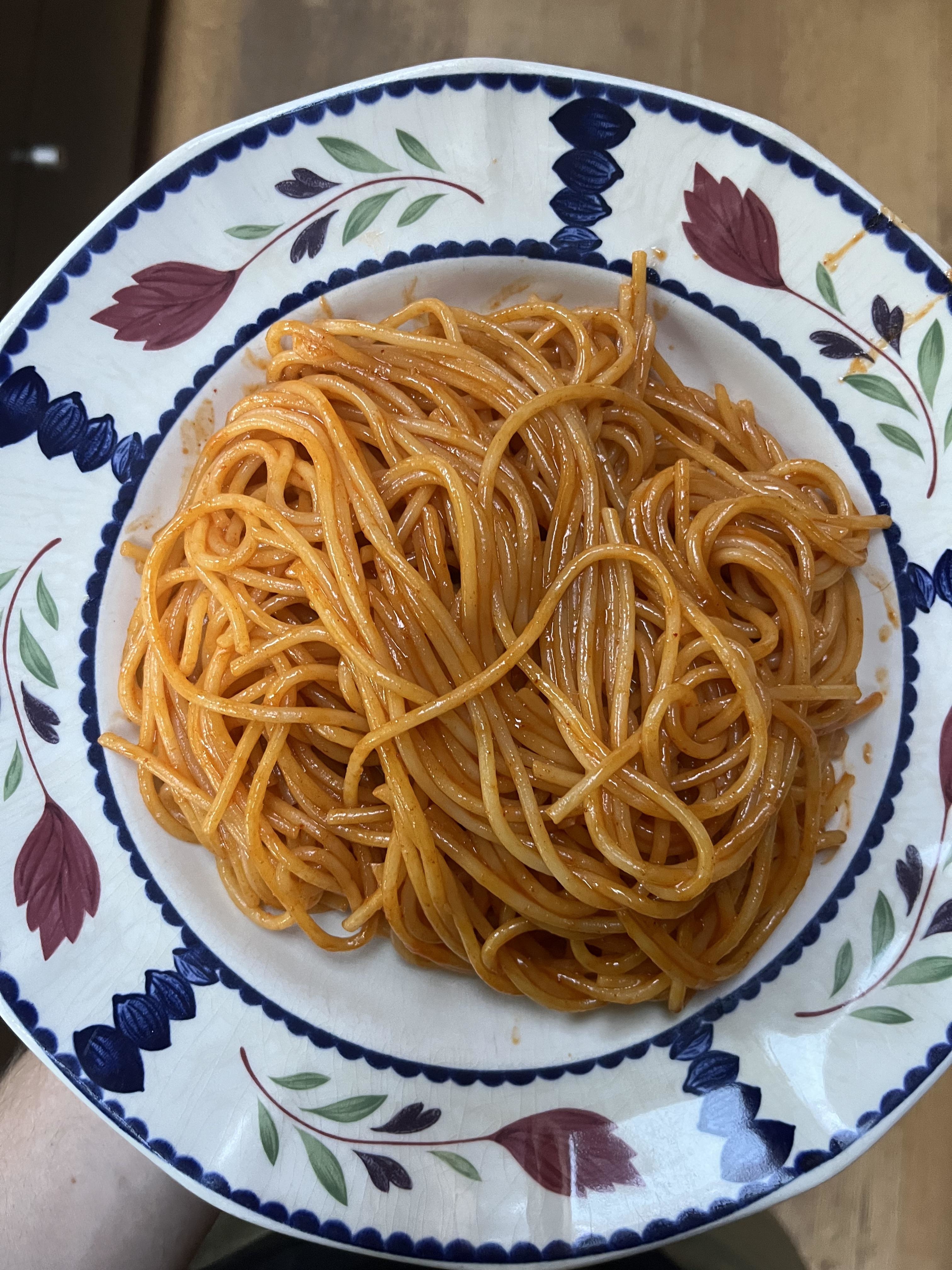 Plate of spaghetti with tomato sauce on a patterned plate