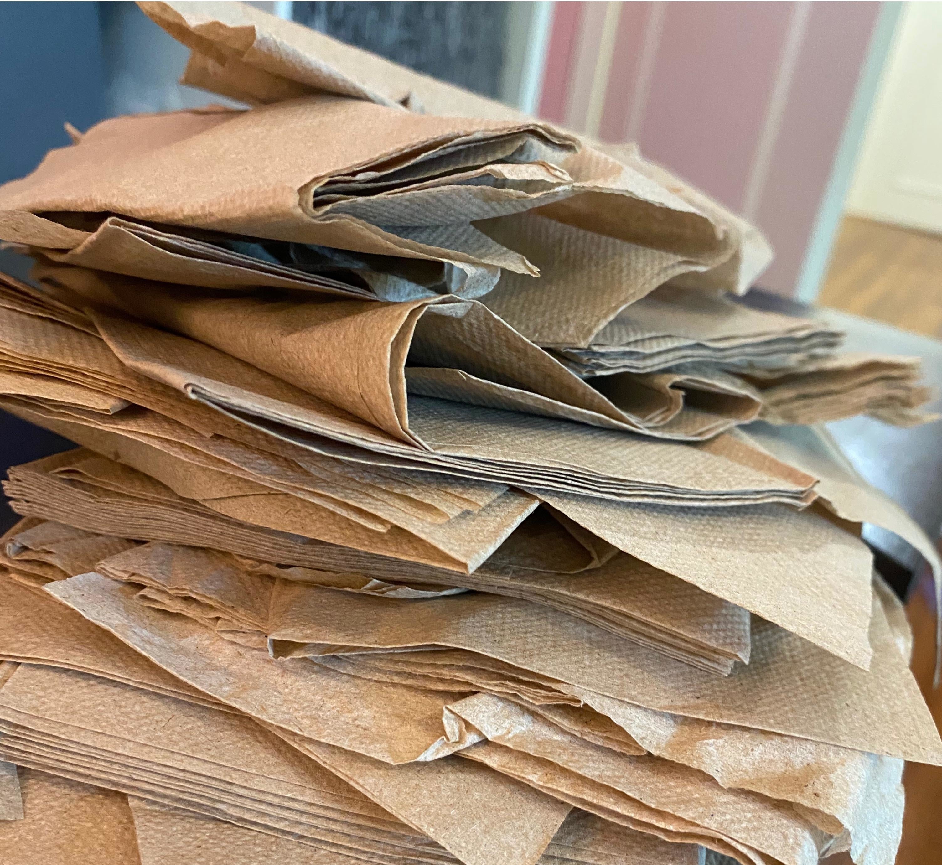 A stack of brown paper napkins on a wooden table