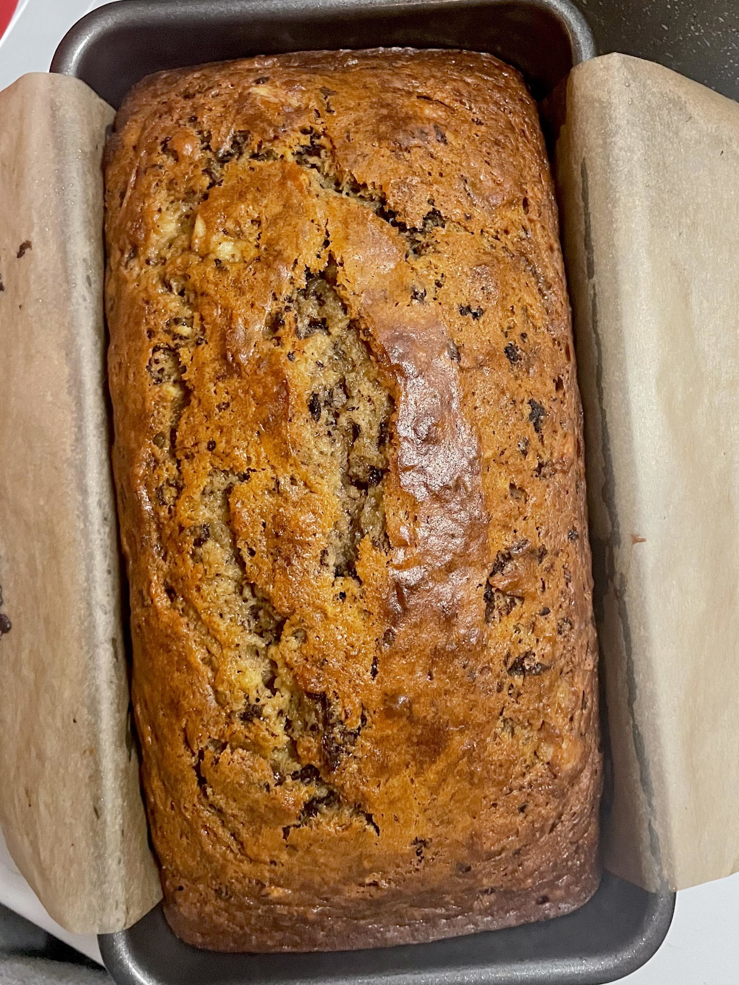 Freshly baked loaf of banana bread with nuts in a baking pan