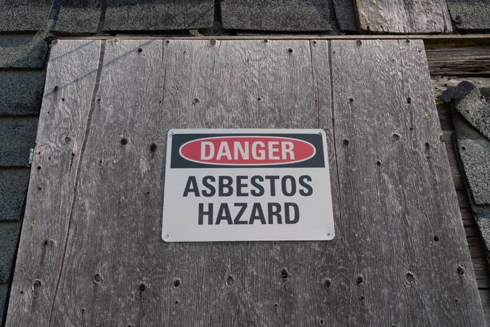 Sign on wall warns of asbestos hazard