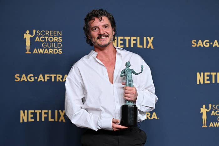 Pedro Pascal in a semi-formal white shirt holding a Screen Actors Guild award
