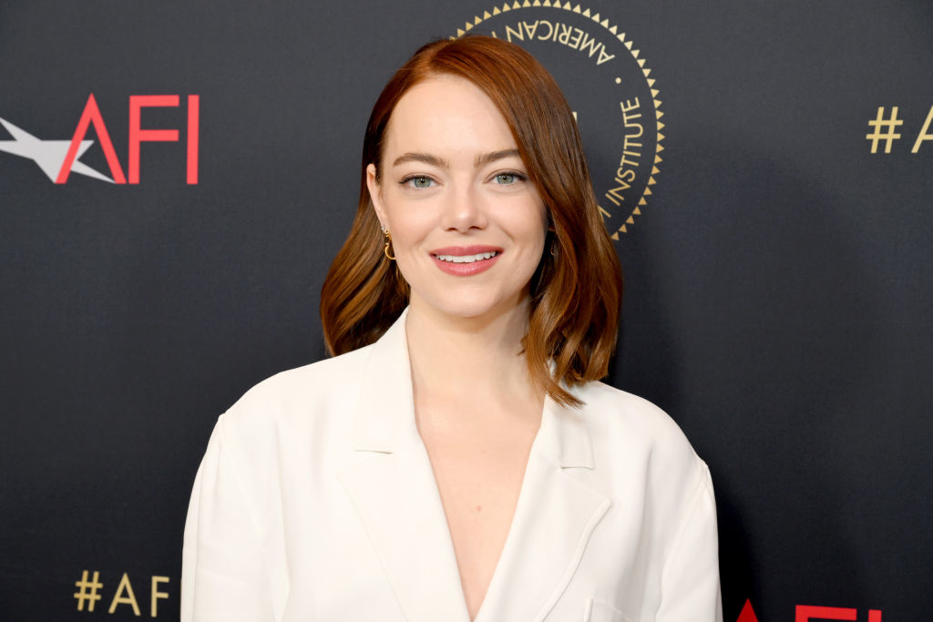 Emma Stone in a white blazer, posing at the AFI event