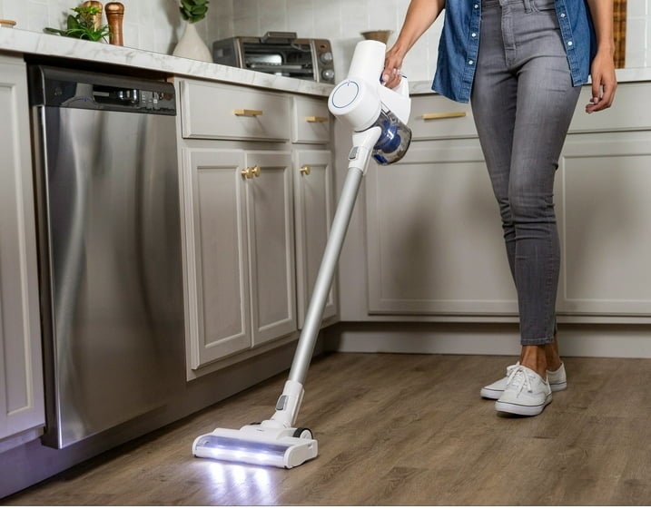 Person holding a cordless vacuum cleaner, emphasizing the convenience of a long battery life for uninterrupted cleaning