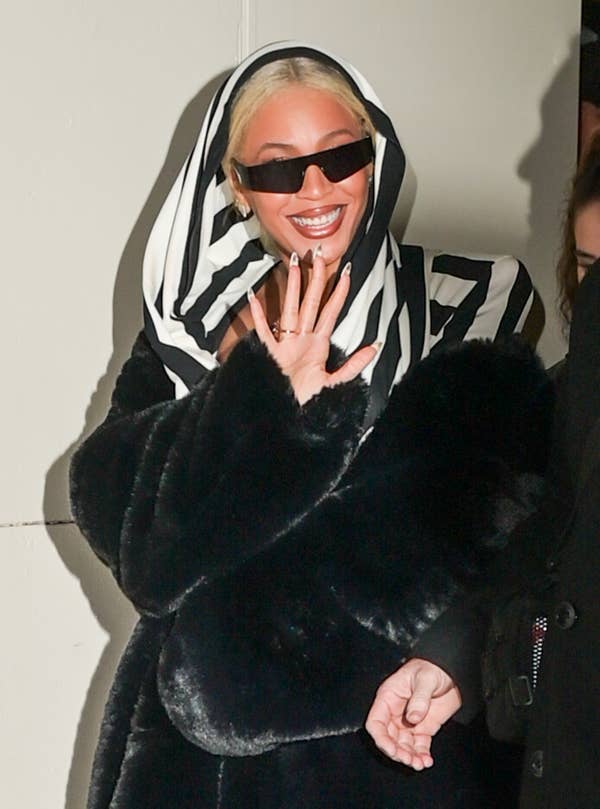 Closeup of Beyoncé waving as she exits a business