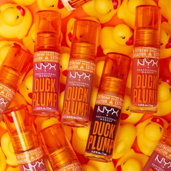 Product representation of NYX Duck Plump articulator gloss with rubber duckies successful the background