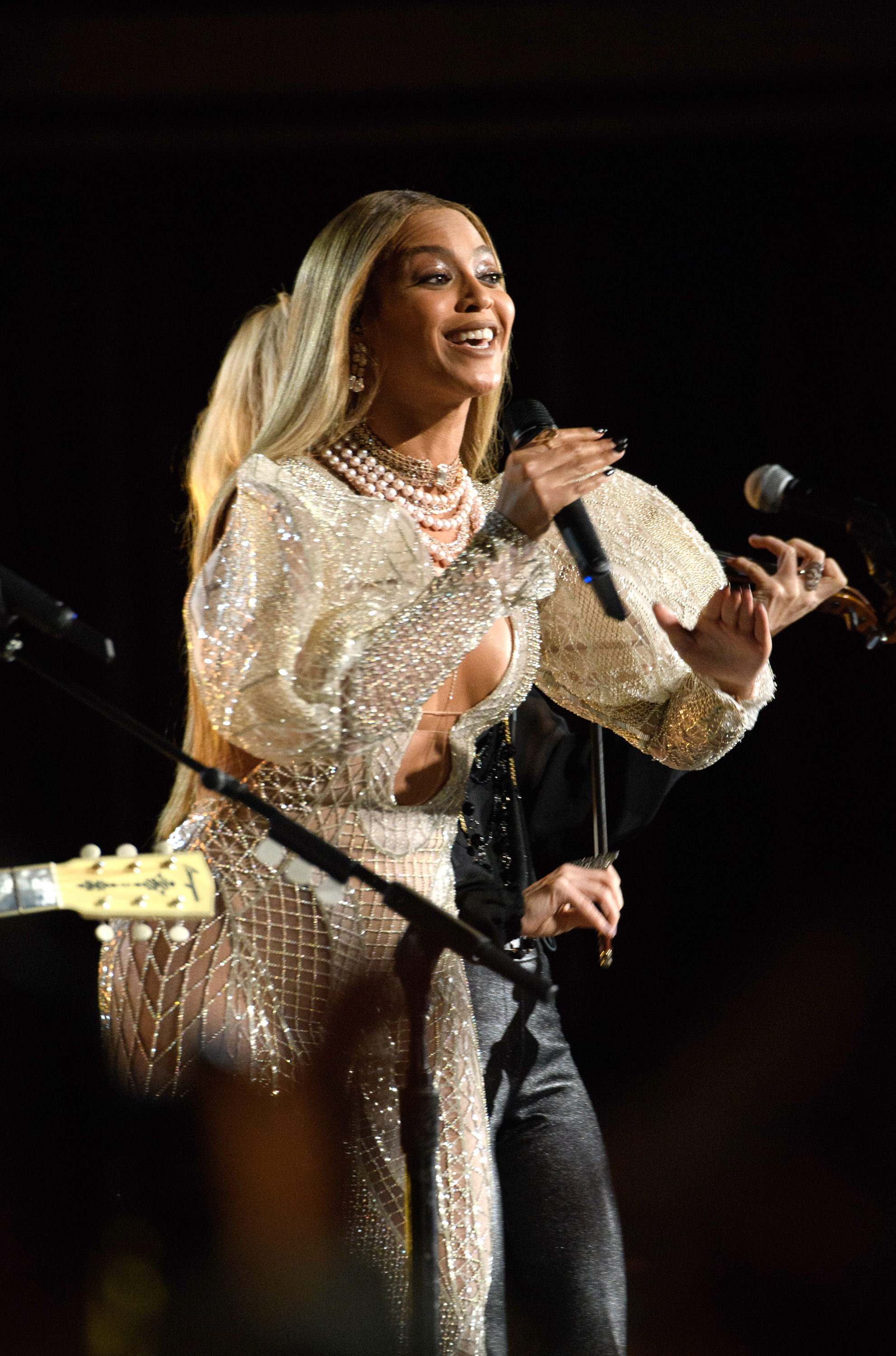Beyoncé singing on stage, wearing a beaded dress