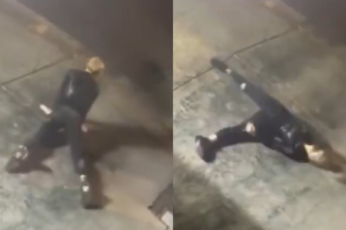 Person in dark suit and boots slips and falls on pavement