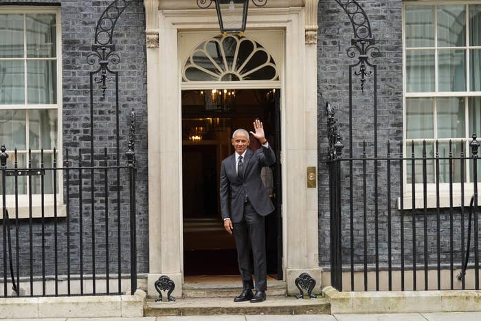 Barack Obama waving as he stands in the doorway of 10 Downing Street