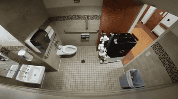 Overhead view of an accessible public restroom with various facilities and a trash can