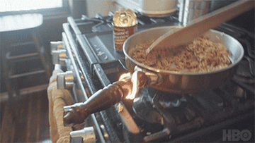 Person cooking on a stove, stirring a pan with wooden spoon, a can beside them