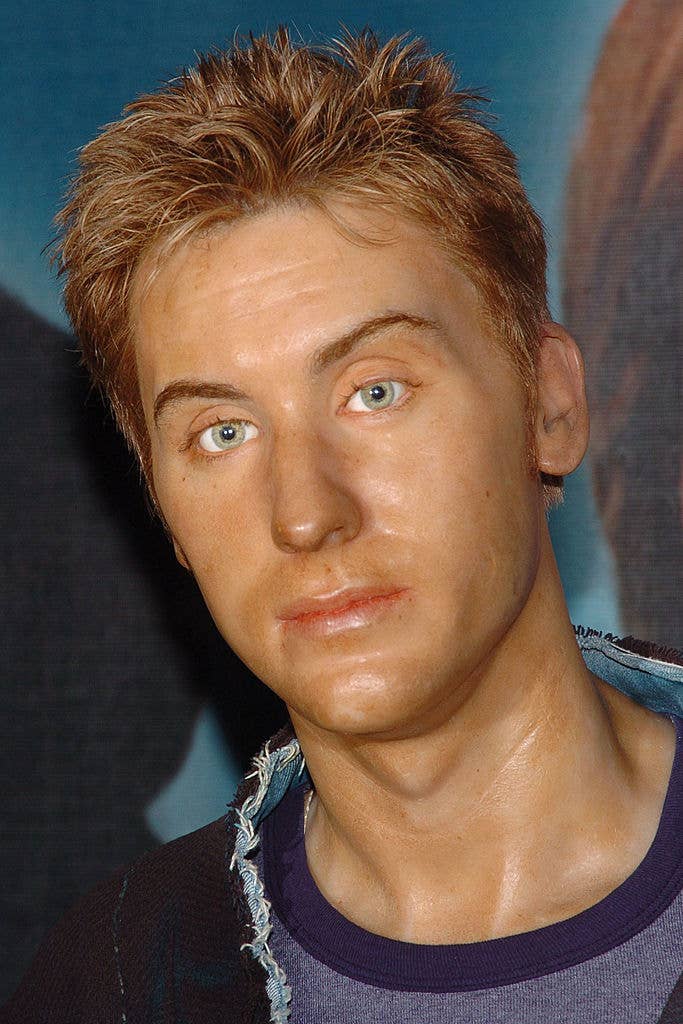 Wax figure resembling Lance Bass with textured hair and a denim jacket
