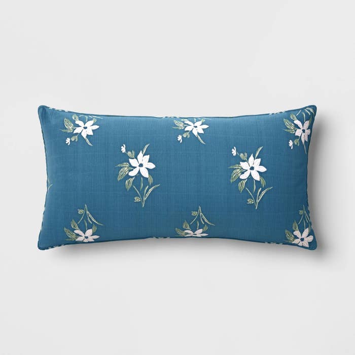 A floral-patterned pillow on a neutral background