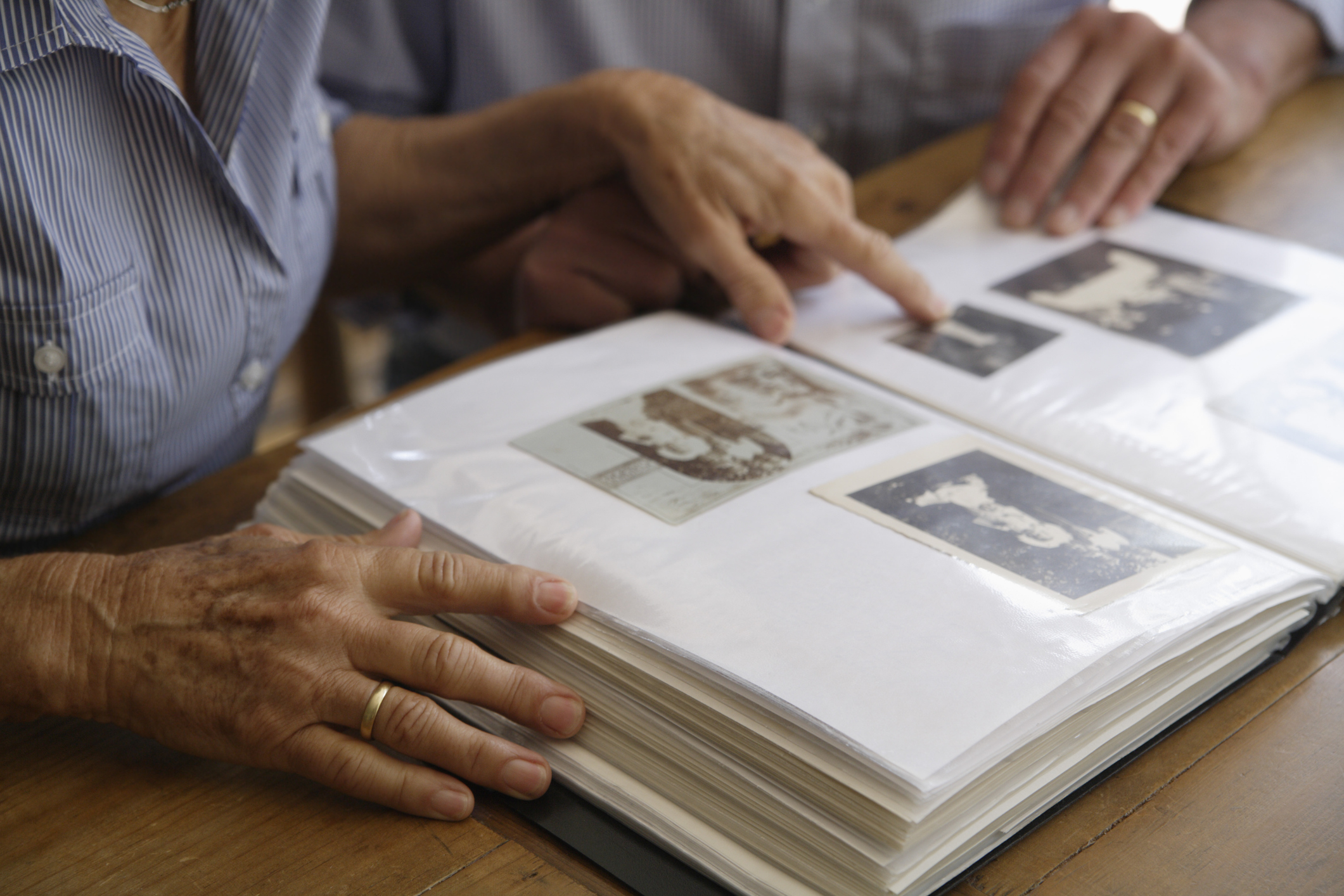 Two people looking at a photo album with vintage pictures